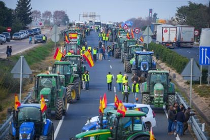 Agricultores cortan una carretera en Écija (Sevilla), este martes. 