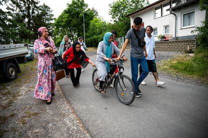 Sima Rahmati, refugiada afgana en Fulda, Alemania, intenta aprender a andar en bicicleta con la ayuda de sus hijos, adoptando así una de las costumbres occidentales.