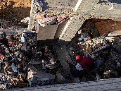 Los vecinos de un barrio de Rafah buscan supervivientes entre los escombros de un edificio bombardeado por Israel este jueves.