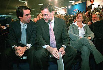 Aznar, con Rajoy, durante la convención del PP. Al lado del candidato, su mujer, Elvira Fernández.