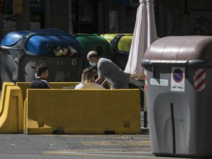 Una terrassa d'un bar al carrer Aragó, situada entre contenidors. 