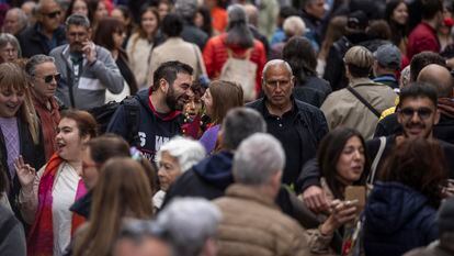 Dos personas se sonríen entre la multitud viandantes, en la Rambla de Barcelona, este martes durante el día de Sant Jordi.