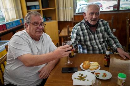 Juan Flores, de 68 años (izquierda), brinda con su cuñado, Jesús García, de 66, en el bar JF 83 de Fuenlabrada.