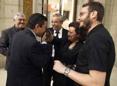 El concejal Pedro Calvo (PP) besa la mano de Milagros Hernández (IU) vestida de luto para el pleno.