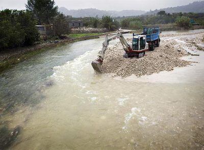 Una pala excavadora vaciaba ayer el cauce del río Girona en la zona de la Vall d'Ebo, donde se desbordó la noche del miércoles.