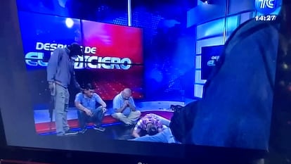 Trabajadores en el piso mientras hombres encapuchados les apuntan en el estudio de la televisora TC, este martes en Guayaquil.