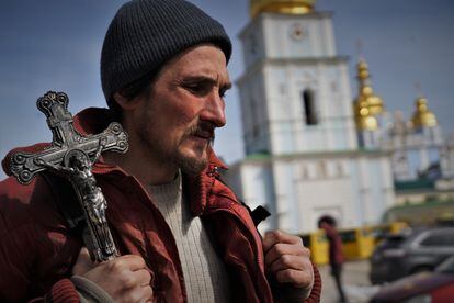 Un hombre se pasea con un crucifijo por los alrededores del monasterio de San Miguel de Kiev.