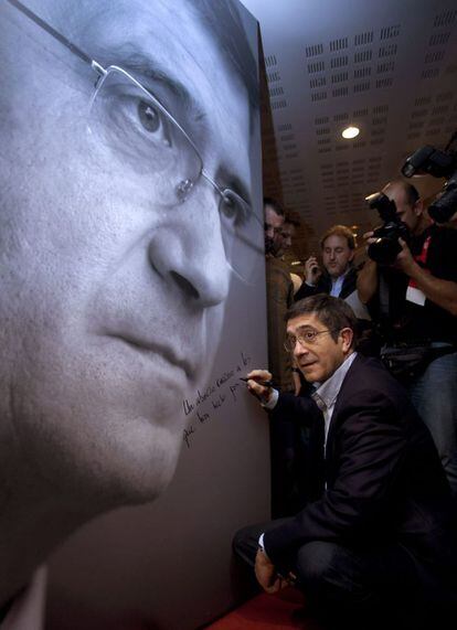 El lehendakari en funciones y candidato a la reelección, Patxi López, firma sobre un póster suyo antes de comparecer tras saber los resultados de las elecciones al Parlamento Vasco.