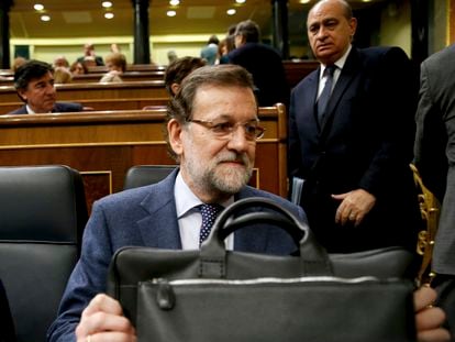 Mariano Rajoy (en primer término), con la cartera de presidente, en la sesión plenaria de control al Gobierno en el Congreso de los Diputados, y Jorge Fernández Díaz, ministro del Interior, en 2015.