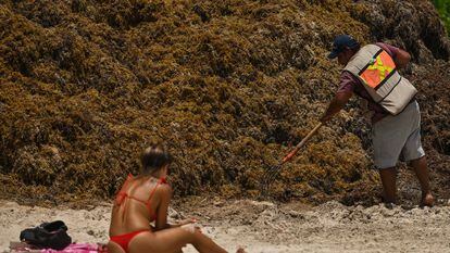 Una turista en la playa Punta Esmeralda (Playa del Carmen) repleta de sargazo.
