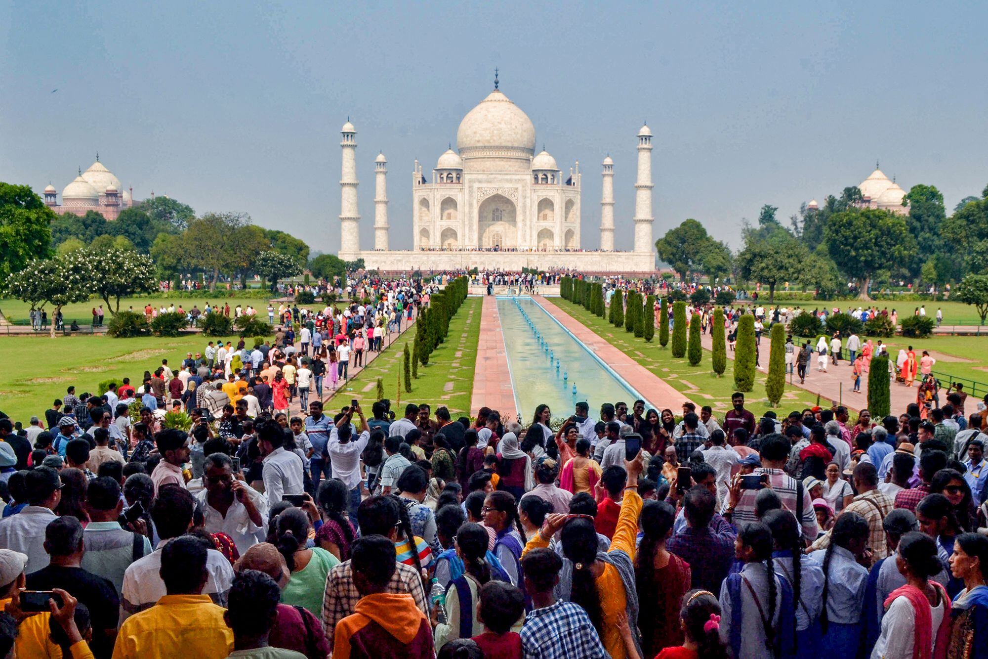 Multitud de turistas esperan para visitar el Taj Mahal en Agra.