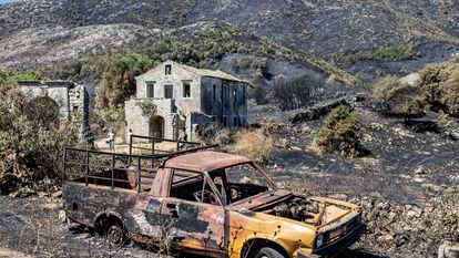 Turistas (al fondo) paseaban el viernes por los restos del incendio en Palia Pericia, una localidad muy afectada por el fuego, que solía ser una importante atracción turística.