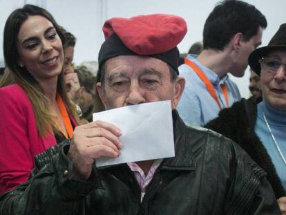 Un hombre con una barretina besa su voto antes de introducirlo en la urna en Barcelona.