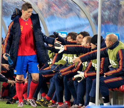 Fernando Torres saluda a sus compañeros de la selección en el banquillo tras se sustituido en el segundo tiempo.
