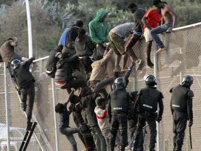 Agentes de la guardia civil junto a los inmigrantes que intentaron saltar la valla en Melilla, el 14 de octubre de 2014.