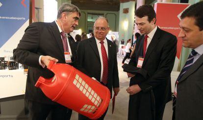 Un delegado de PDVSA muestra una bombona a un representante de Repsol ante el embajador de Venezuela, Mario Isea, segundo por la izquierda.