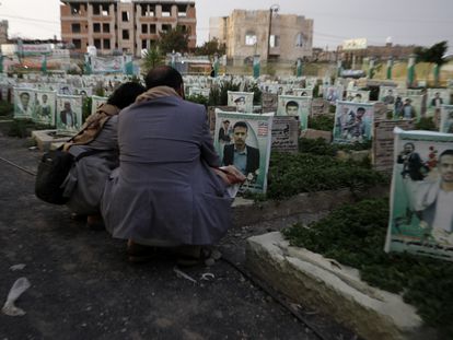 Dos yemeníes visitan la tumba de un pariente muerto en la guerra, en un cementerio de la capital, Saná, el 10 de abril de 2023.