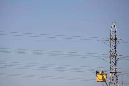 Dos operadores trabajan en una línea eléctrica en las afueras de Sevilla.