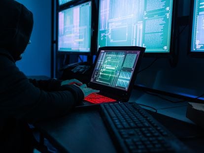 Hacker asiática con una máscara negra en una sala de servidores.