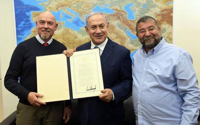 El alcalde de Katsrin, Simitry Apartsev, y el primer ministro israelí, Benjamín Netanyahu, el miércoles en Jerusalén con una copia del documento firmado en la Casa Blanca. A la derecha, Haim Rokah, presidente del Consejo Regional del Golán.