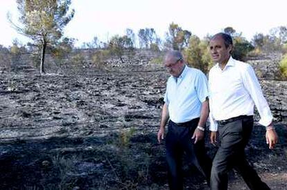 El presidente de la Generalitat Valenciana, Francisco Camps, junto al alcalde de Rafelguaraf, Federico Tormo, durante la visita que ha realizado hoy a la zona quemada en este municipio.