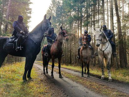 Policías polacos a caballo en la frontera entre Polonia y Bielorrusia cerca de Kuznica, el 11 de noviembre. Ciudadanos de Oriente Próximo, así como de países africanos, aterrizan en Minsk en vuelos operados por distintas compañías aéreas. Por ello, la presidenta de la Comisión Europea, Ursula von der Leyen, advirtió el mismo lunes que el Ejecutivo comunitario está explorando “cómo sancionar, incluso mediante la inclusión en listas negras, a las aerolíneas de terceros países que participan activamente en la trata de personas”.