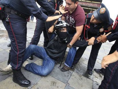 Un manifestante es detenido ayer, en la Ciudad de M&eacute;xico
