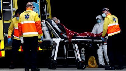 Personal sanitario traslada a un enfermo en la entrada de urgencias del Hospital de Bellvitge