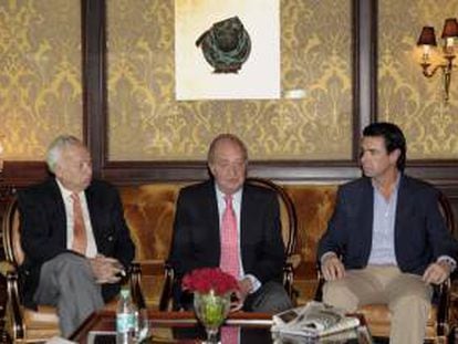 El rey Juan Carlos, junto al ministro de Asuntos Exteriores, José Manuel García-Margallo (i), y el ministro de Industria, Energía y Turismo, José Manuel Soria (d), durante la conversación que ha mantenido hoy, antes de emprender viaje de regreso a España, con los periodistas que han cubierto su visita oficial a la India, en la que ha dicho que considera "muy productivo" para los intereses españoles el resultado de su visita y se muestra convencido de que, en las negociaciones europeas frente a la crisis, España saldrá adelante "con el cuchillo en la boca" y con "una sonrisa".