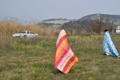 Dos migrantes se tapan con mantas en una playa de Steccato di Cutro.