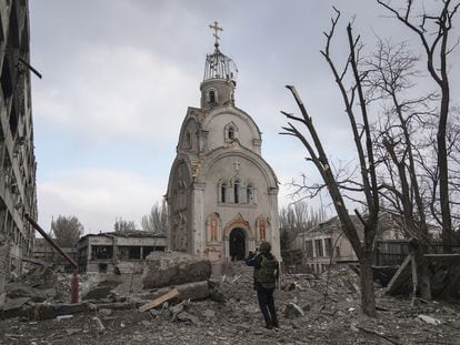 Zona residencial después de un bombardeo, un militair ucrania saca una foto a una iglesia  Marioupol, Ucrania, 10 marzo, 2022.