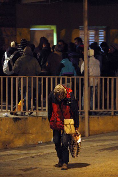 Un grupo de indigentes aguarda para lograr cama en un albergue municipal de Madrid.