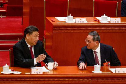 El presidente chino, Xi Jinping, habla con el primer ministro entrante, Li Qiang, durante la reunión de la Asamblea Popular Nacional, este viernes en Pekín.