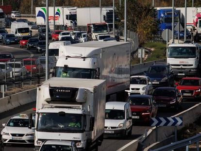 Camiones y otros vehículos en una autopista a su paso por Madrid.