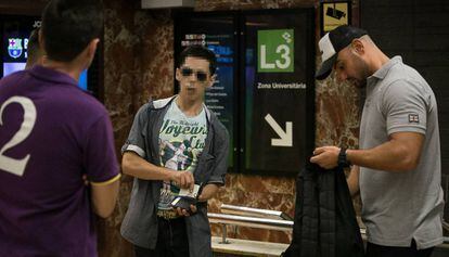 Dos guardas urbanos registran a un presunto carterista en el metro de Barcelona.