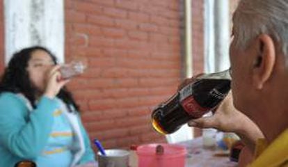 Dos personas consumen refrescos en Ciudad de México. EFE/Archivo