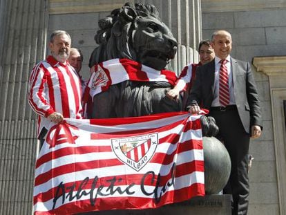 Diputados del PNV colocan una bufanda del Athletic de Bilbao a un le&oacute;n del Congreso de los Diputados.
