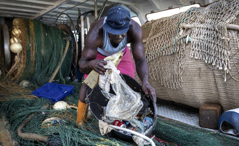 Un marinero enseña la basura recogida en el mar ese día por uno de los barcos de arrastre de Dénia.