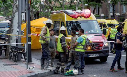 Un grupo de trabajadores junto al edificio en rehabilitación siniestrado.