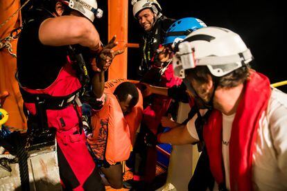 Una de las personas rescatadas es ayudada a subir al barco 'Aquarius', el 9 de junio de 2018.