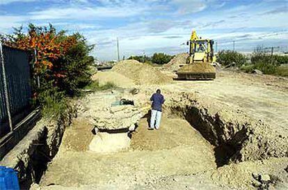 Unos operarios rellenan el agujero conocido hoy junto a las vías del tren, que Fomento atribuye al trabajo de una excavadora en unas obras.