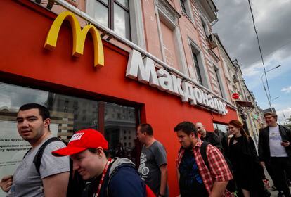 Unos ciudadanos pasan por delante de un McDonald's cerrado, este sábado en Moscú.