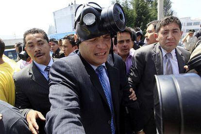 El presidente Rafael Correa, con máscara de gas tras resultar ligeramente herido en un intercambio de golpes en un cuartel de la policía.