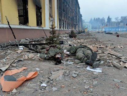 Los cuerpos de dos soldados rusos, junto a una escuela destruida durante los combates en la ciudad de Járkov.