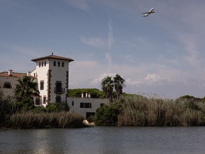 un avión que acaba de despegar del Aeropuerto del Prat sobrevuela la laguna del espacio natural de La Ricarda. / ALBERT GARCIA