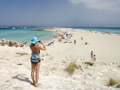 Una mujer fotograf&iacute;a la playa de Ses Illetes, en Formentera (Islas Baleares). 