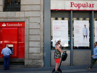 Varias personas pasan por delante de una sucursal del Banco Popular en Madrid.