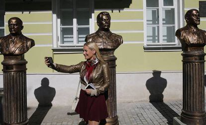 Una mujer se hace una foto delante de las esculturas de los líderes soviéticos Nikita Jruschev, Stalin y Lenin, en Moscú.