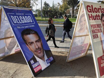 Personas caminan frente a carteles de propaganda electoral para consejeros Constitucionales, el 27 de abril 2023, en Santiago (Chile).