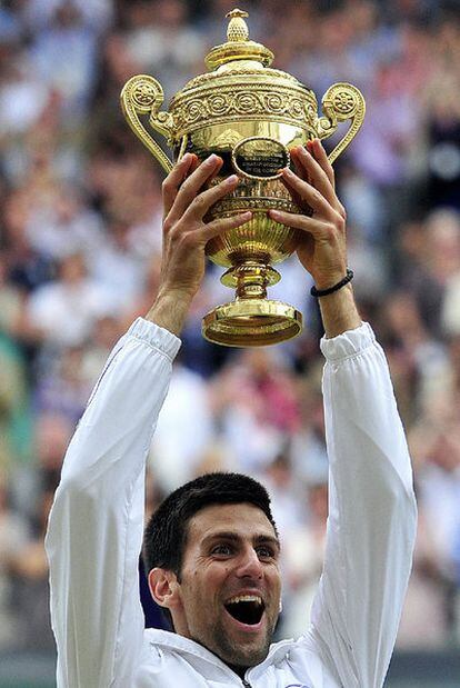 Novak Djokovic alza, eufórico, el trofeo de campeón de Wimbledon.